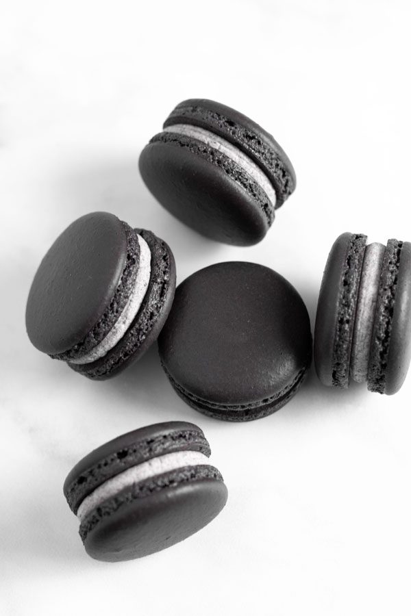black macarons on white background