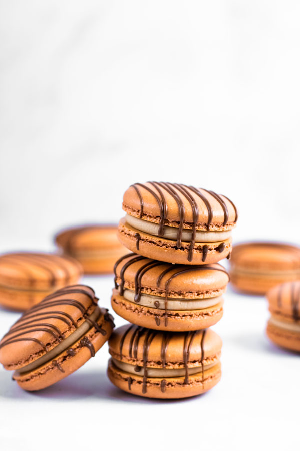 stack of chocolate macarons with chocolate drizzle