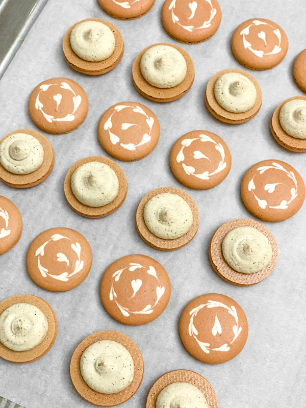 coffee macaron shells with coffee buttercream on baking tray