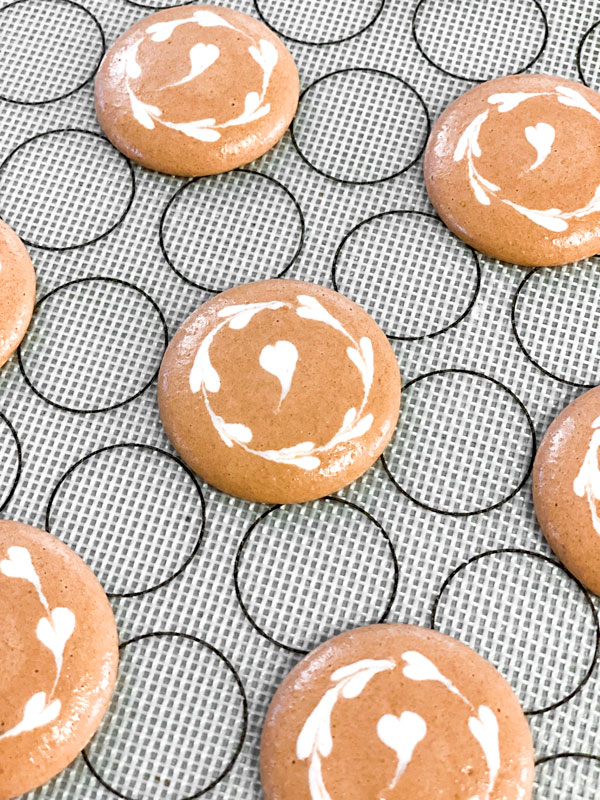 decorated coffee macarons on silicone baking mat