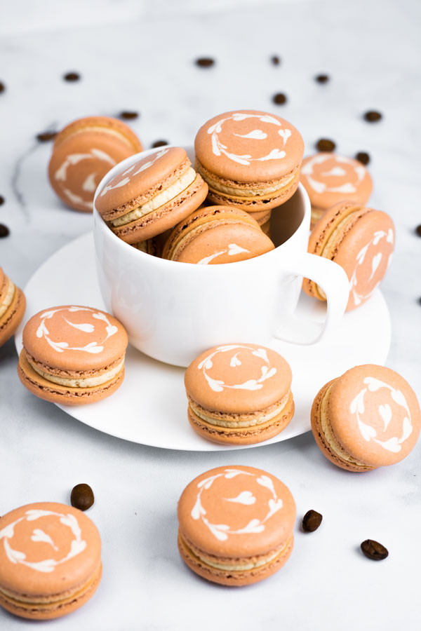 coffee macarons in white coffee mug and white plate