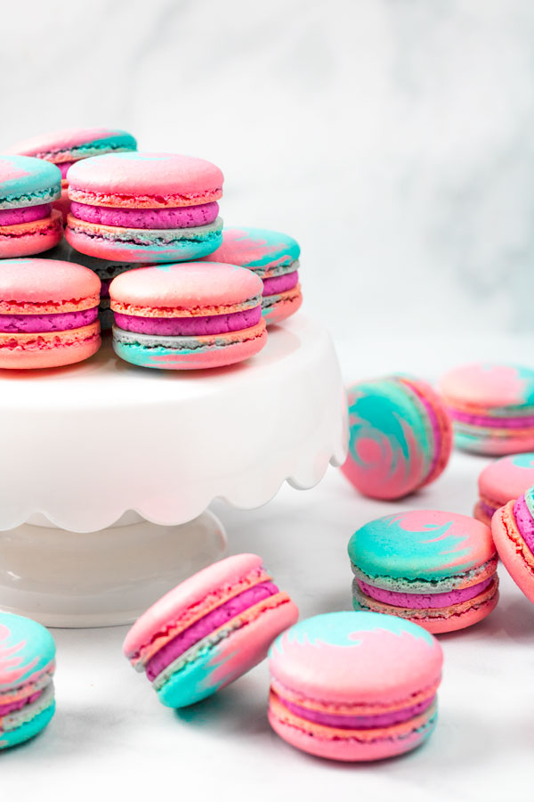 blue and pink cotton candy macarons on white cake stand