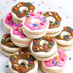 tower of donut macarons with pink and brown decorations and sprinkles