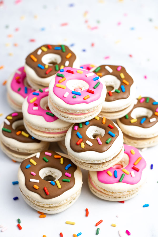 tower of donut macarons with pink and brown decorations and sprinkles