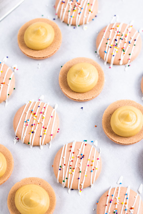 macarons with dulce de leche buttercream and sprinkles on baking sheet