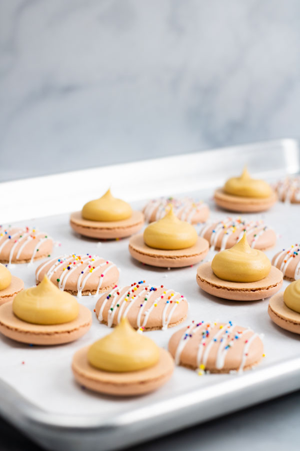 macarons with dulce de leche buttercream on baking sheet