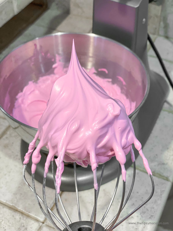 pink meringue on whisk next to mixing bowl