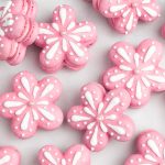 pink flower shaped macarons with white icing decorations