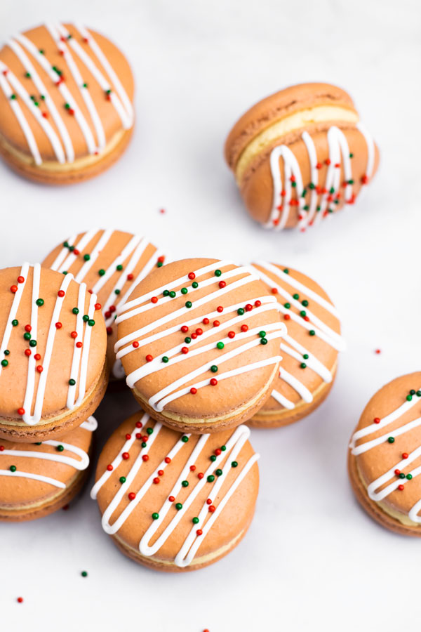 gingerbread macarons with white royal icing and green and red sprinkles