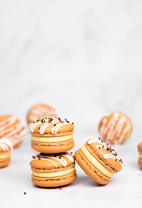 three gingerbread macarons in front of macarons