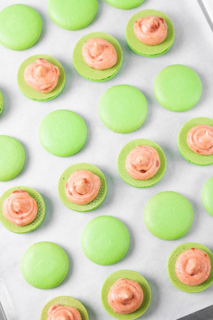 guava macaron shells with piped guava buttercream