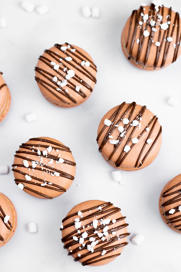 hot chocolate macarons drizzled with chocolate and mini marshmallow bits