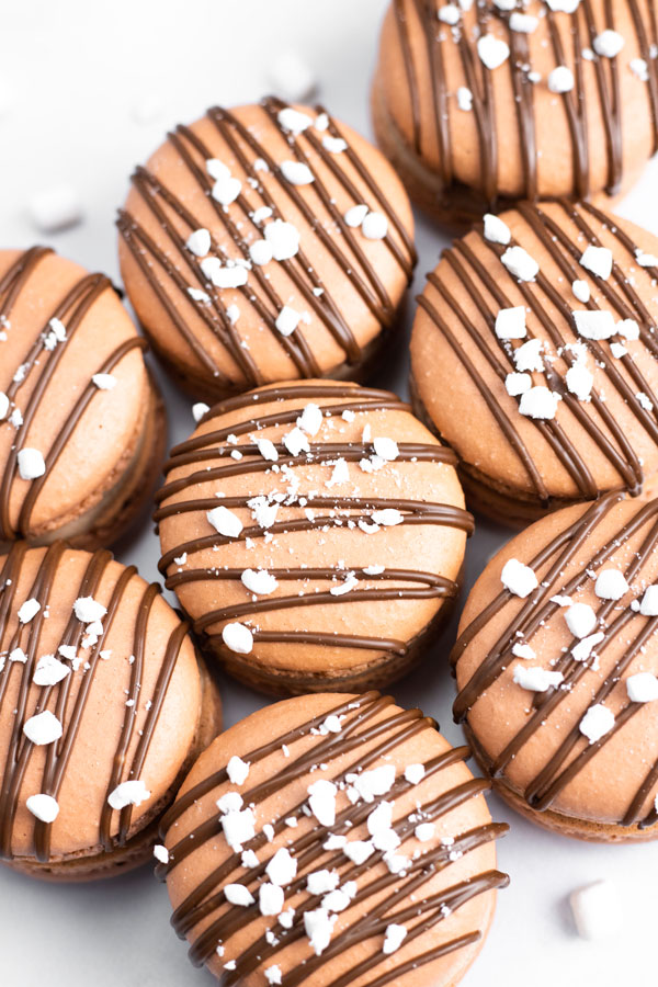 group of chocolate macarons drizzled with chocolate and marshmallow bits