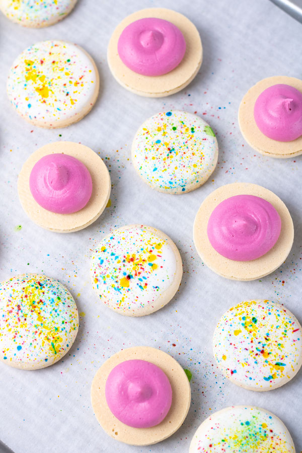 splatter paint macaron shells with pink buttercream