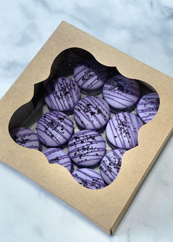 purple french macarons in brown box