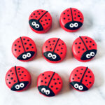 group of red ladybug macarons with white background