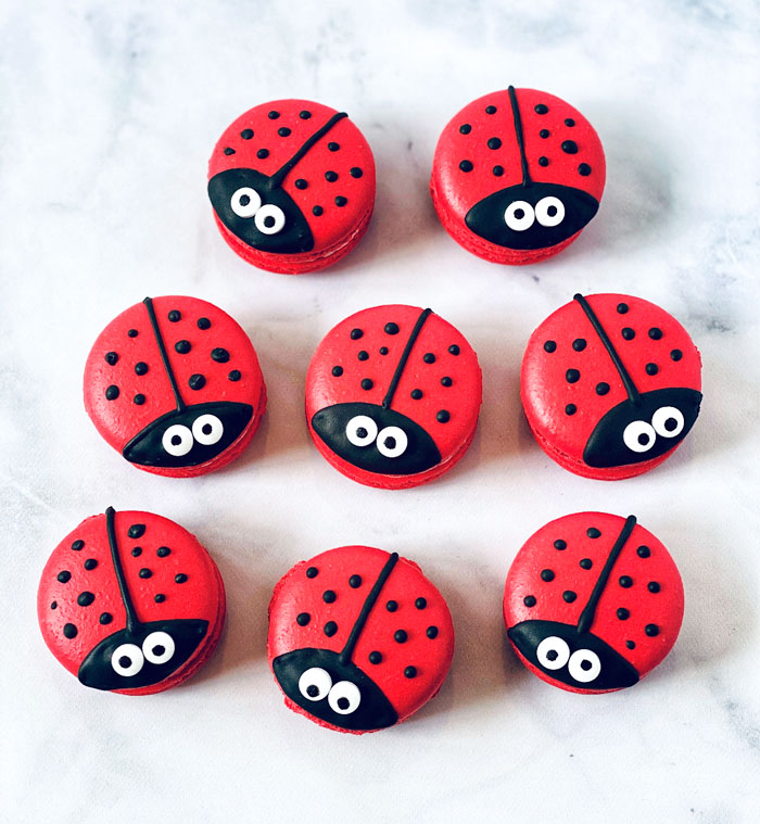 group of red ladybug macarons with white background