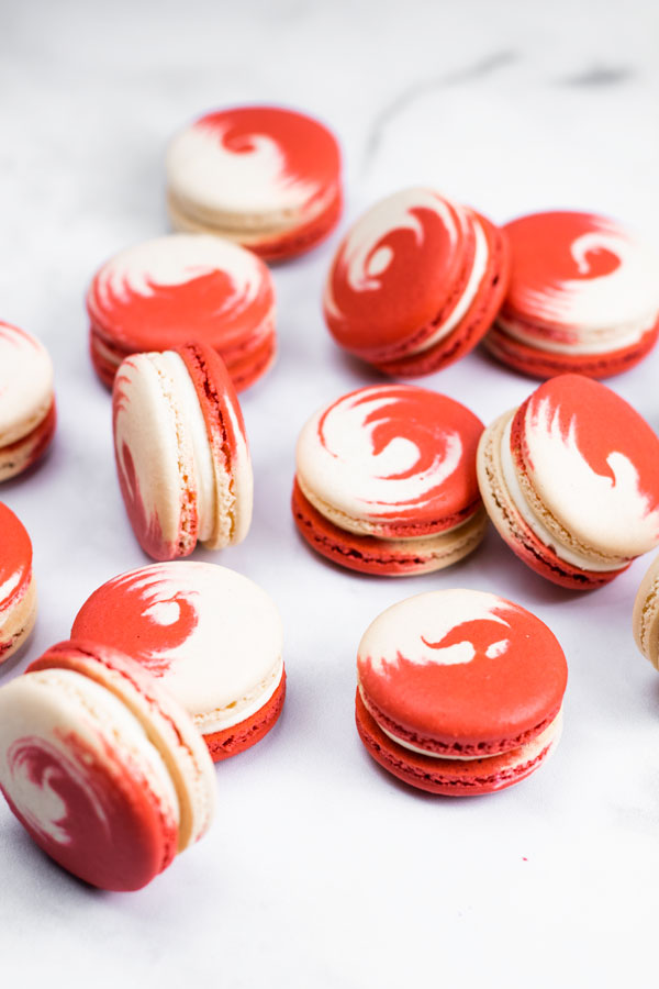 red and white swirled strawberry cheesecake macarons