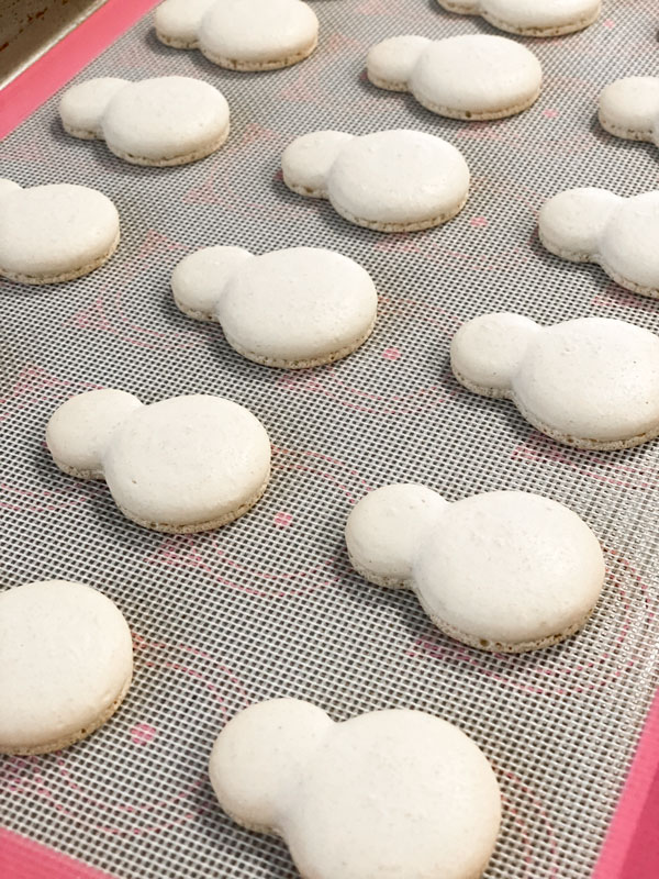 baked snowman macaron shells on baking mat