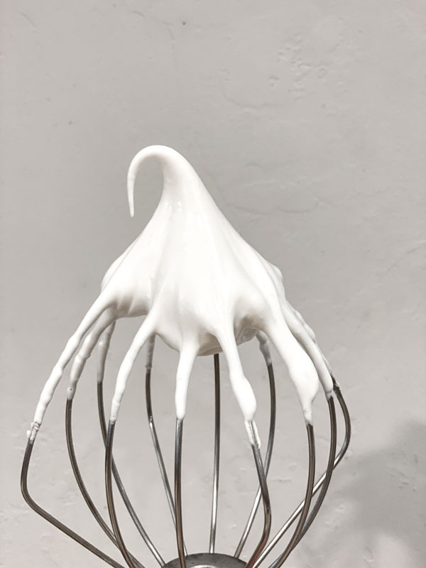 whisk with white soft peak meringue