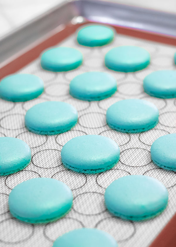 baked turquoise macaron shells on baking tray