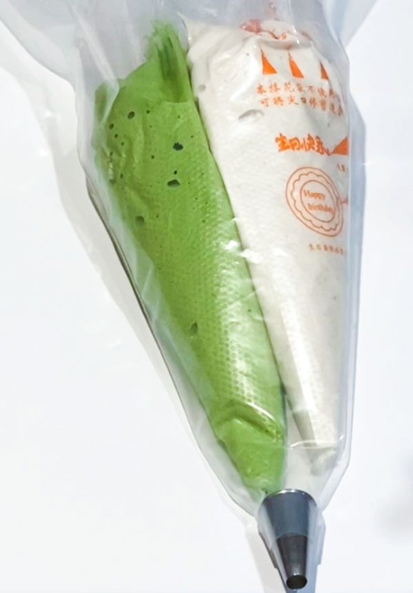 green and white matcha macaron batter in piping bag