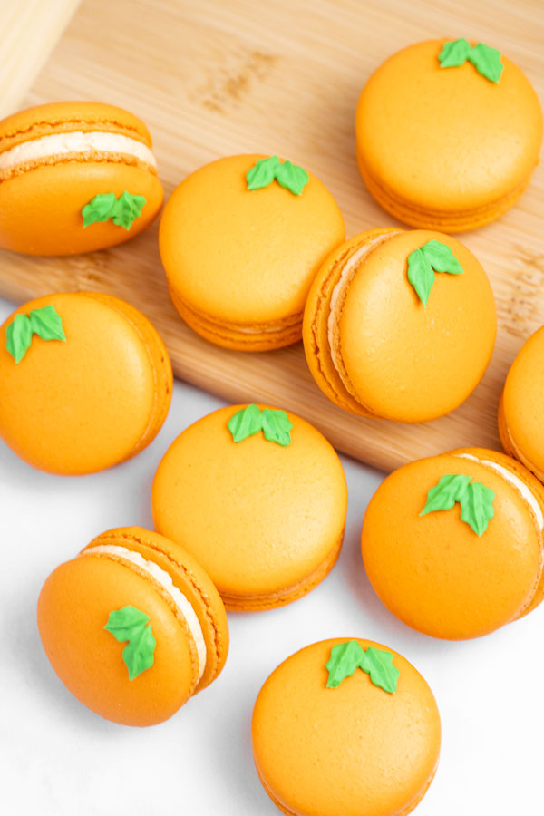 orange macarons on wood cutting board