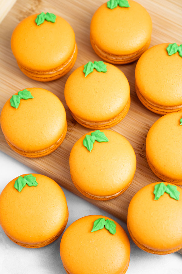 orange macarons on wood cutting board