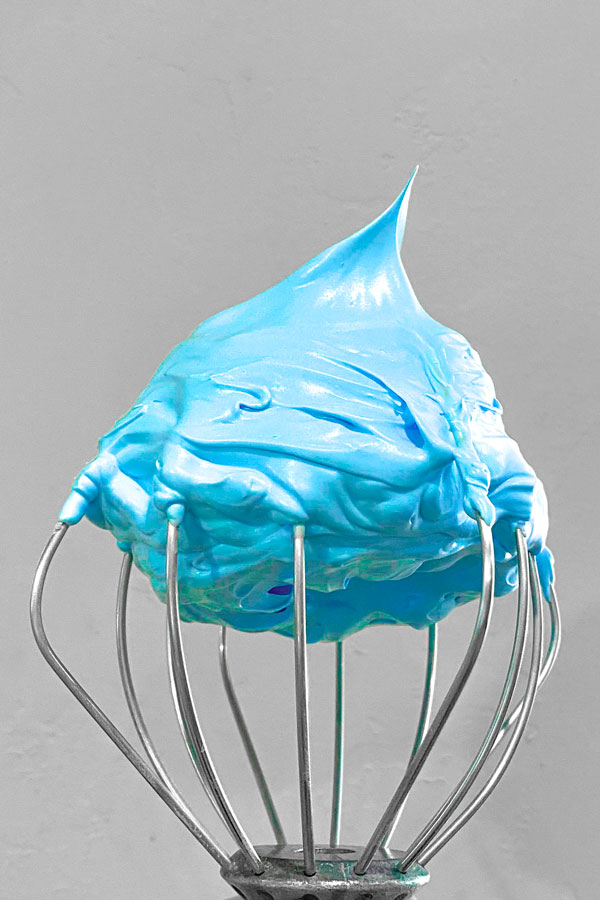 whisk with blue stiff peak meringue