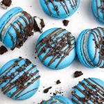 blue oreo macarons with chocolate drizzle and crushed oreos