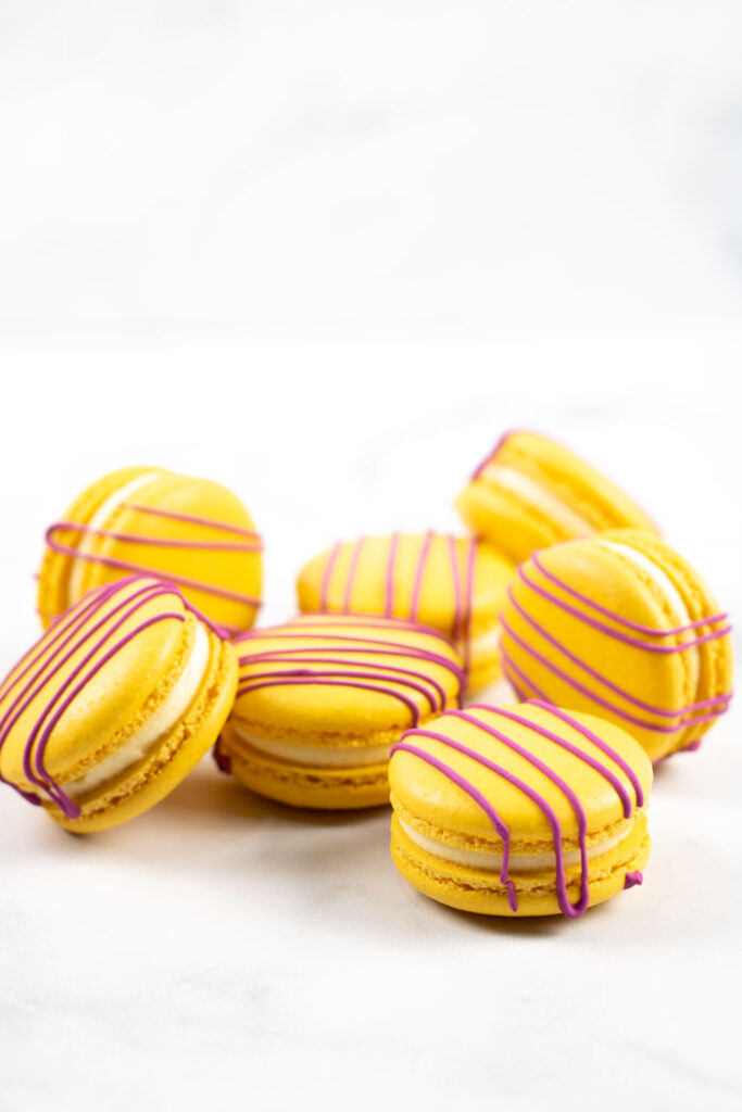 yellow macarons with red drizzle on marble background