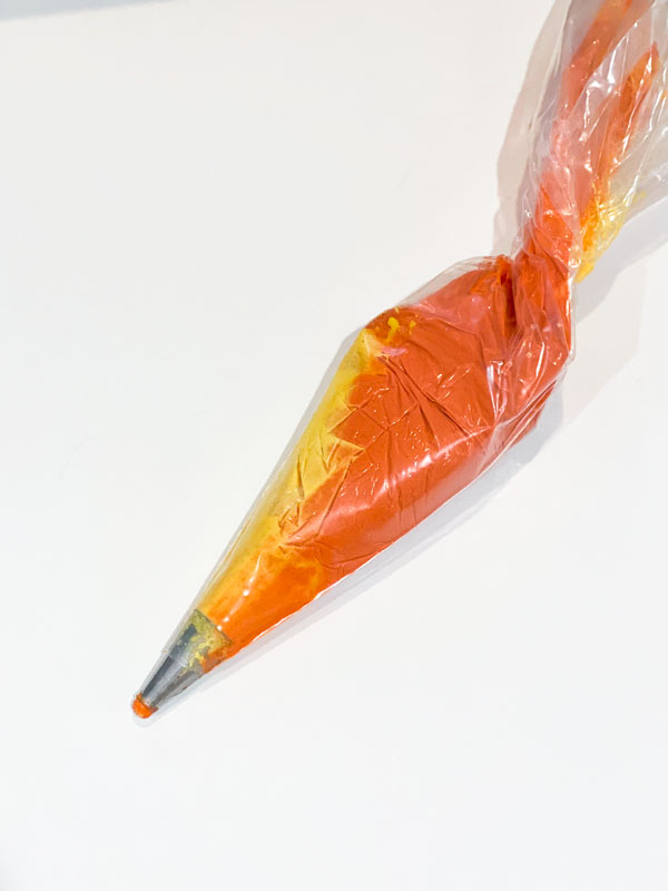 orange and yellow peach macaron batter in piping bag