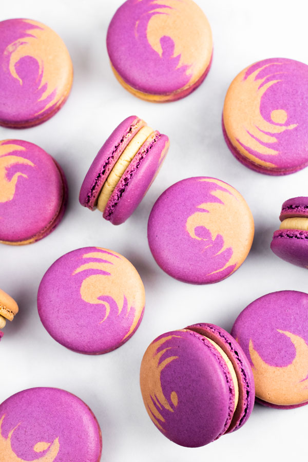 purple and brown peanut butter and jelly macarons on white background
