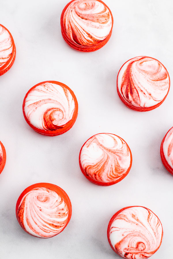 candy cane macarons decorated with marbled royal icing