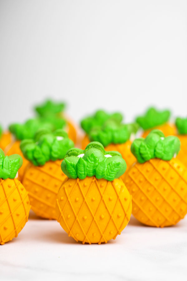 orange and green pineapple macarons standing upright