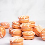 Orange pumpkin spice macarons with white drizzle