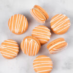 orange salted caramel macarons with white drizzle and salt
