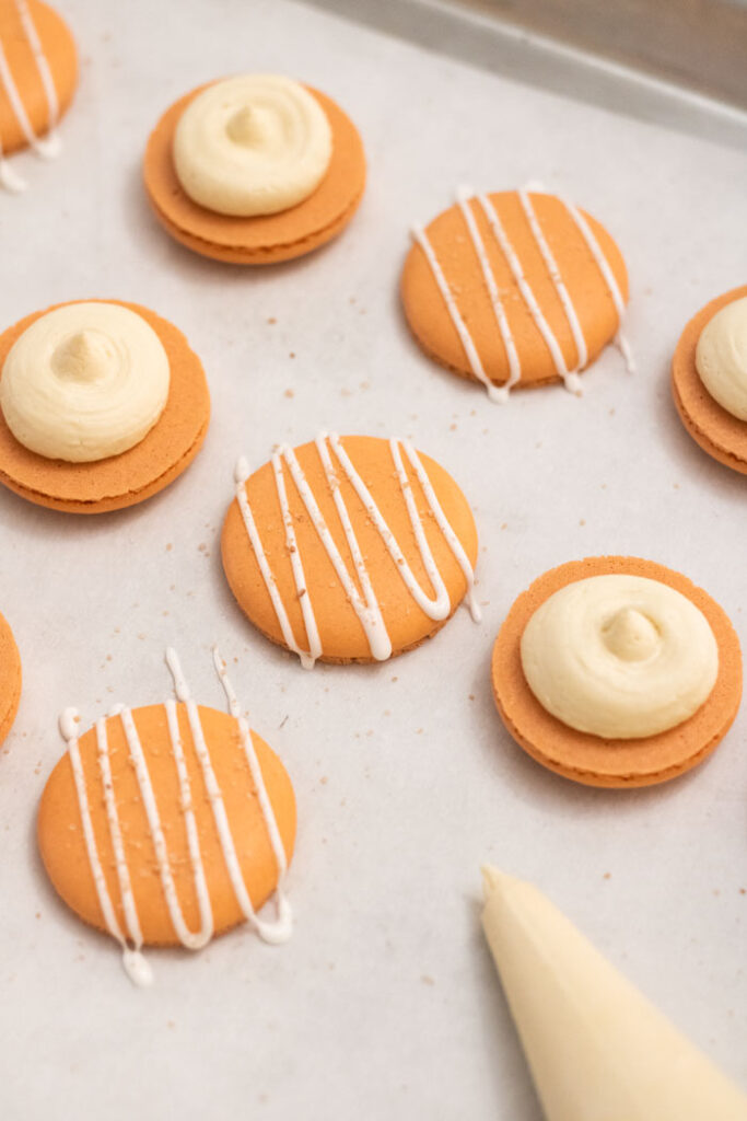 orange salted caramel macaron shells with white buttercream