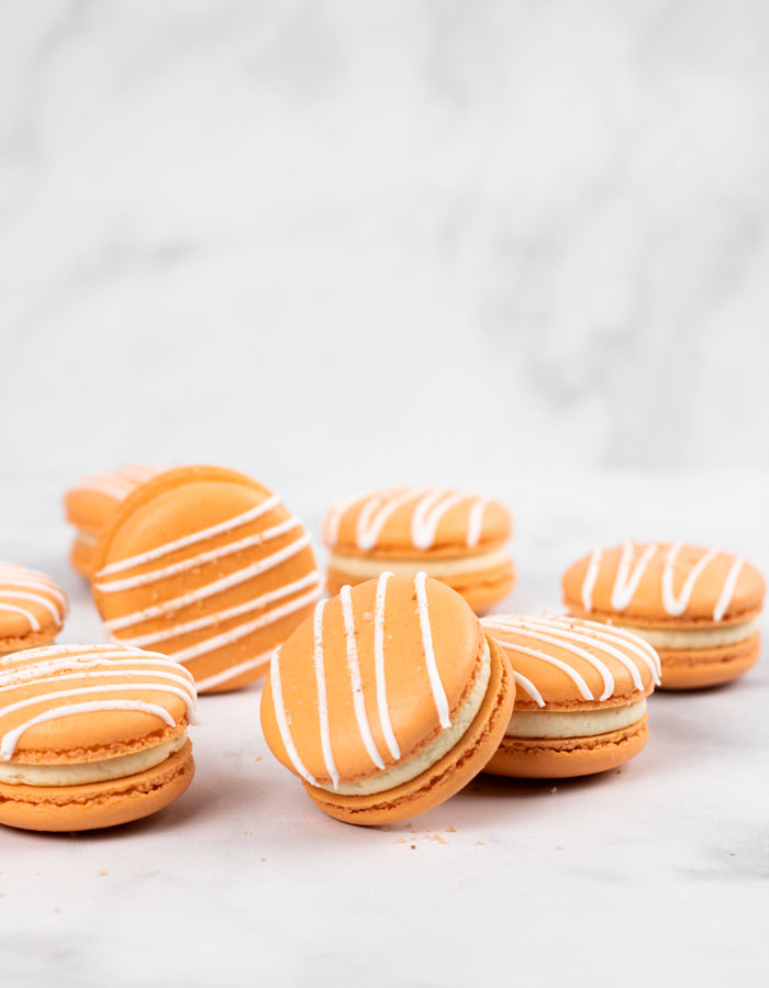 orange salted caramel macarons with white drizzle