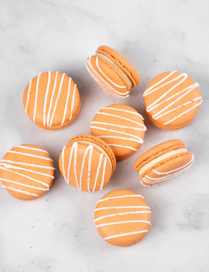 orange salted caramel macarons with white drizzle and salt