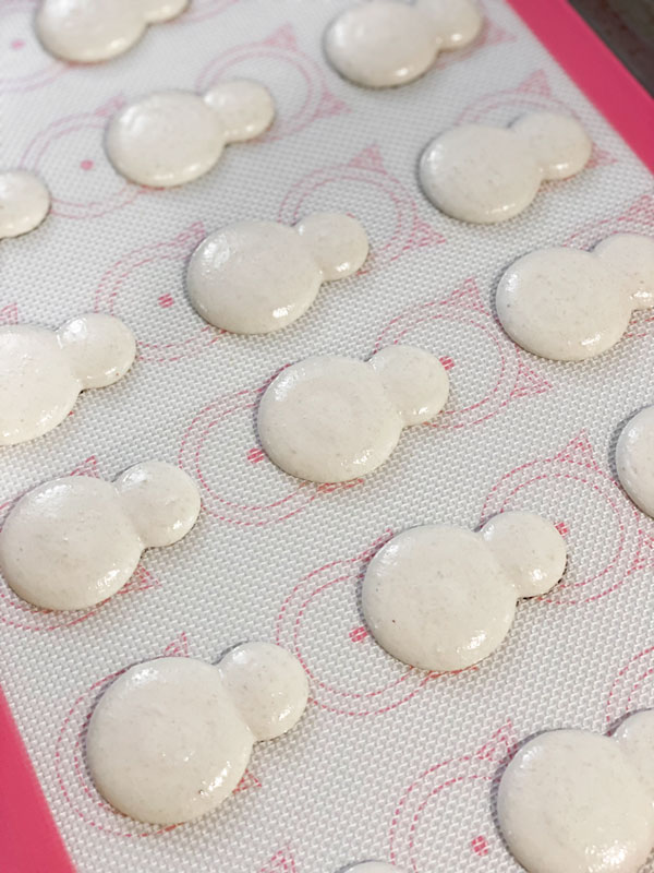 snowman macarons on silicone baking mat