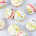splatter paint macarons with pink buttercream on white background