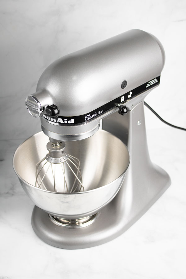 silver stand mixer with stainless steel bowl and whisk