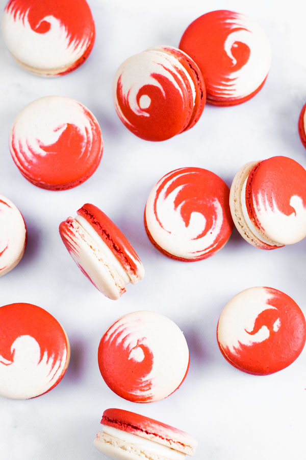 red and white swirled strawberry cheesecake macarons