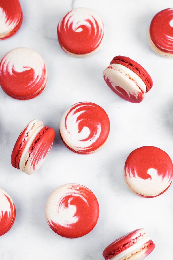 red and white swirled strawberry cheesecake macarons