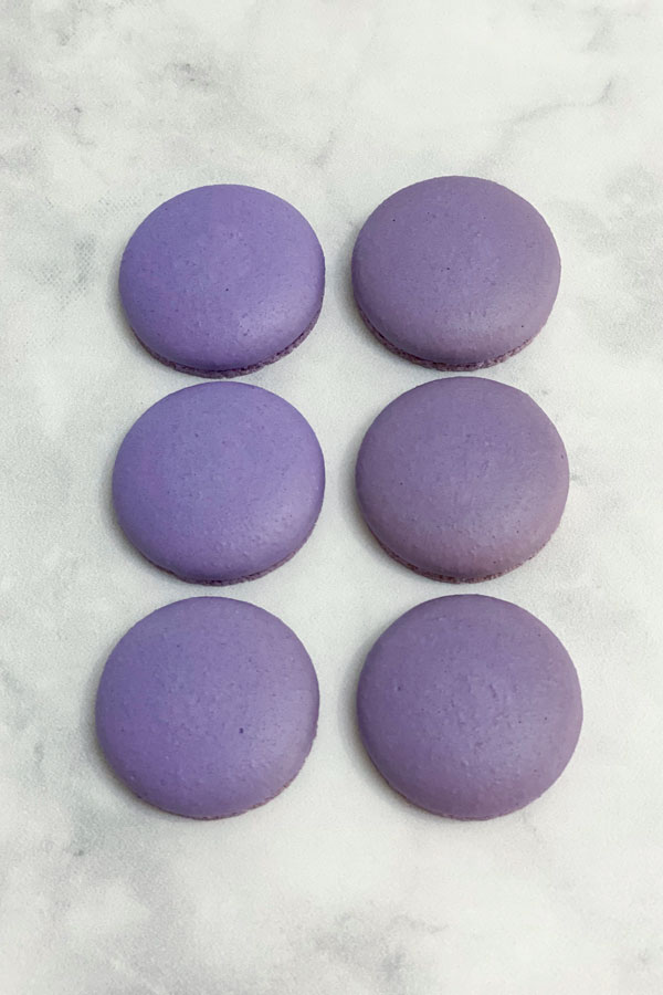 purple macarons shells on marble countertop