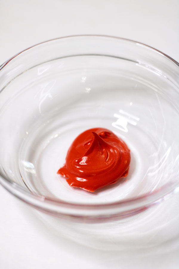 Red royal icing in glass bowl