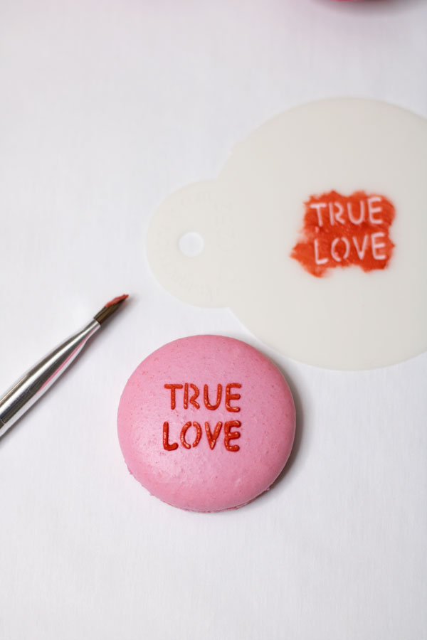 Light pink conversation heart macarons with painbrush and stencil
