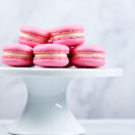 pink vanilla macarons on white cakestand