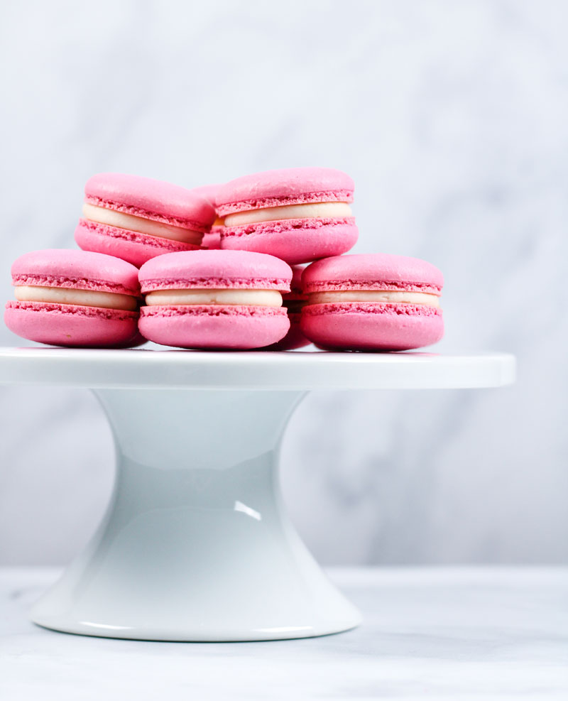 pink vanilla macarons on white cakestand